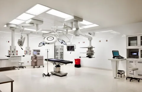 An operating room at St. Joseph's University Medical Center, equipped with an operating table, overhead surgical lights, and wall-mounted monitors.